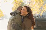 Happy couple hugging on urban autumn bridge