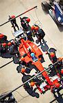 Overhead pit crew working on formula one race car in pit lane