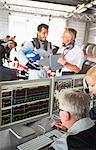 Formula one team reviewing diagnostics in repair garage