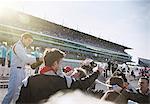 Formula one racing team and driver spraying champagne, celebrating victory on sports track