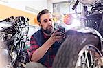 Motorcycle mechanic doing diagnostic test on motorcycle in workshop