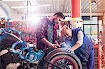 Motorcycle mechanics repairing motorcycle in workshop