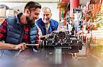 Male motorcycle mechanics repairing engine in workshop