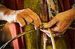 Close up of woman weaving a basket in weaver's workshop.