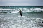 Athlete in wet suit running in the sea