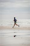Athlete running along the beach on a sunny day