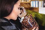 Close-up of beautiful woman smelling a jar of spice in shop