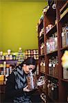 Beautiful woman smelling a jar of spice in shop