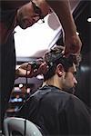 Man getting his hair trimmed with trimmer in barber shop