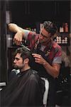 Man getting his hair trimmed with scissor in barber shop