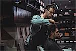 Barber styling clients hair in baber shop