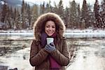 Portrait of a beautiful woman in fur coat holding coffee cup in winter