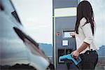 Woman using plug-in electric machine on street