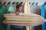 Man selecting surfboard in a shop