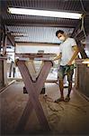 Man making surfboard in workshop