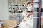 Pregnant businesswoman having fruit juice in office cafeteria