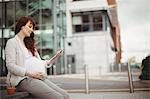 Pregnant businesswoman holding digital tablet in office premises