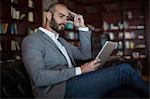 Businessman using digital tablet in waiting area at airport terminal