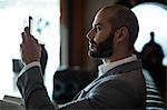 Businessman using mobile phone in waiting area at airport terminal