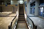 Empty escalator next to waiting area in airport terminal