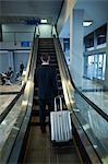 Rear view of businessman on escalator at airport