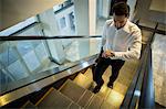 Commuter looking time while walking on escalator in airport