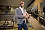 Businessman using digital tablet at airport