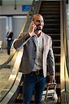 Businessman talking on mobile phone at airport