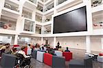 Students at a lecture in the atrium of a modern university