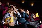 Couple In Cinema Wearing 3D Glasses Watching Horror Film