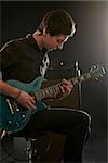 Man Playing Electric Guitar In Studio