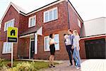 Realtor Outside House For Sale With Young Family