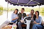 Group Of Friends Enjoying Day Out In Boat On River Together