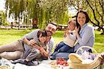 Family Enjoying Riverside Picnic Together