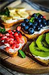 Healthy fruit open sandwiches on a wooden board