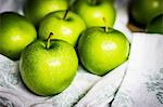 Freshly washed green apples on a tea towel