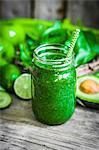 A green smoothie on a rustic wooden surface