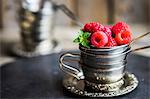 Fresh raspberries in a stack of silver cups