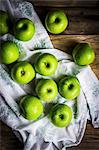 Bright green apples on wooden surface