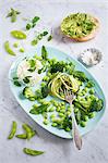 A green salad made of courgette spaghetti, Edamame beans, broccoli, water cress, bloodwort, baby spinach with ricotta, avocado bagel