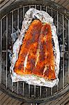 Spiced salmon in aluminium foil on a barbecue