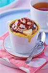 A mug cake with pineapple, a scoop of ice cream and chocolate sauce