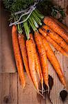 A bundle of fresh carrots on a wooden board