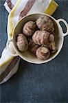 Fresh Jerusalem artichokes in a colander on a tea towel