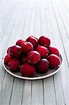 Fresh plums in white bowl