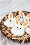 Easter bunny cookies on a wooden plate with straw