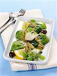 Hake and lettuce rolls with a green olive sauce and lemons