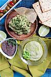 Three dips: guacamole, olive paste and pea cream