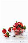 Fresh strawberries in a glass dish and next to the dish