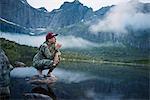 Woman at lake brushing teeth